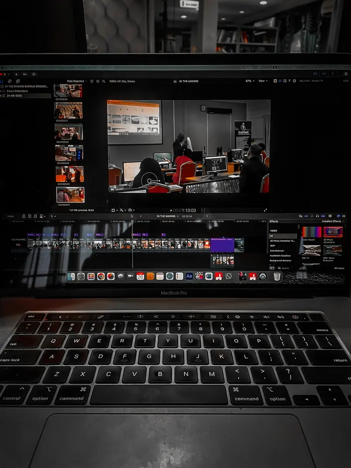 A laptop open on a video editing timeline, footage and scopes on screen