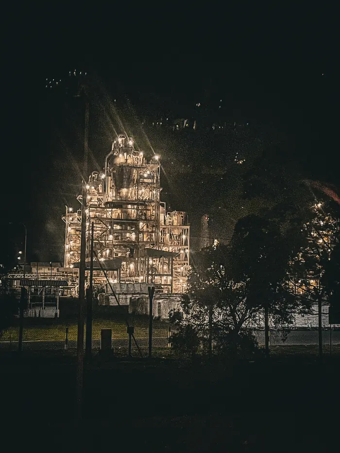 An industrial processing plant picked out in work lights against a black sky
